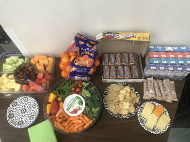 Photo of an array of snacks and juice boxes on a tabletop. 